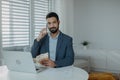 Businessman man counting euro money working on computer at office desk, using smartphone and looking at camera Royalty Free Stock Photo