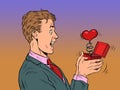 A businessman man looks at a red heart box valentine surprise greeting, love romance