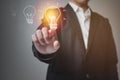 A businessman, a man who touches a light bulb with his finger. Royalty Free Stock Photo