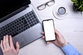 Businessman, man works at desktop on laptop and uses mobile phone. Top view, smartphone, glasses, cup of coffee. Mock up Royalty Free Stock Photo