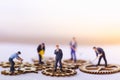 Businessman and many workers standing on wooden gear.