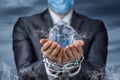 A businessman in a mask with chains on his hands shows the Globe Royalty Free Stock Photo