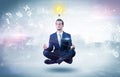 Businessman meditates with enlightenment concept