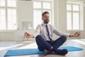 Businessman meditates at the workplace in the office.