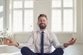 Businessman meditates at the workplace in the office.