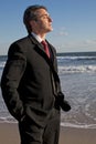 Businessman meditating on the beach