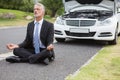 Businessman meditating after his car broken down Royalty Free Stock Photo