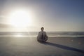 Businessman Meditating In Lotus Position On Beach