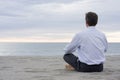 Businessman meditating at the sea