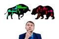 Businessman in the middle of silhouettes bull and bear icons.