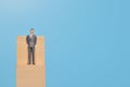 Businessman miniature standing on wooden block with copy space