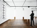 Businessman Modern art museum expo loft interior.Open space studio.Empty white canvas hanging.Wood floor,bricks wall