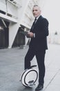 Businessman on a monowheel is searching on a tablet.