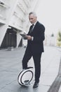 Businessman on a monowheel is searching on a tablet.