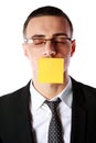 Businessman with mouth covered with a paper card
