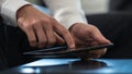 Businessman navigating a tablet computer activating the touchscreen with a finger