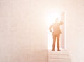 Businessman near open door in sunlit wall with stairs Royalty Free Stock Photo