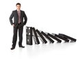 Businessman near a stack of dominoes