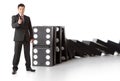 Businessman near a stack of dominoes