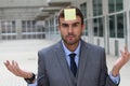 Businessman with a note on his forehead Royalty Free Stock Photo