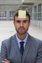 Businessman with a note on his forehead Royalty Free Stock Photo