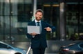 Businessman with notebook outdoor. Confident business expert. Handsome man in suit holding laptop against office Royalty Free Stock Photo