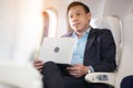 Businessman with notebook sitting inside an airplane Royalty Free Stock Photo