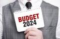 Businessman with notebook with text BUDGET 2024