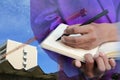 Businessman with notepad in hand signing documents in constru