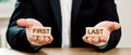 businessman offers a choice of wooden blocks with the inscriptions first and last.