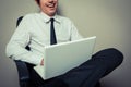 Businessman in office chair working on laptop Royalty Free Stock Photo