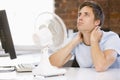 Businessman in office with computer and fan