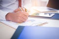 Businessman, office guy working on paperwork at office. Handsome young man writing, analyzing graph, chart of business by using Royalty Free Stock Photo