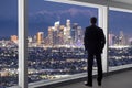 Businessman in an office looking at the view of downtown Los Angeles