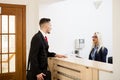 Businessman in office reception area talking with secretary Royalty Free Stock Photo