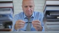 Businessman In Office Room Thinking and Playing With Pen in Hands