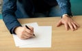 Businessman in the office writes a letter or signs a document on a piece of white paper with a fountain pen with nib. Royalty Free Stock Photo