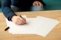 Businessman in the office writes a letter or signs a document on a piece of white paper with a fountain pen with nib. Royalty Free Stock Photo