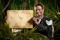 Businessman with old paper parchment in the jungle