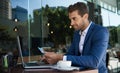 Businessman online shopping while sitting outside at a cafe table Royalty Free Stock Photo