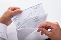 Businessman opening envelope with paycheck