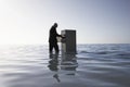 Businessman Opening Filing Cabinet In Sea Royalty Free Stock Photo