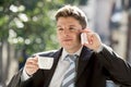 Businessman outdoors in coffee break holding cup talking on mobile phone smiling happy Royalty Free Stock Photo