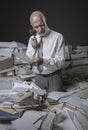 Businessman overwhelmed by work and checking documents with a loupe