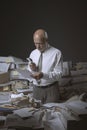 Businessman overwhelmed by work and checking documents with a loupe