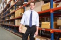 Businessman With Package And Scanner In Warehouse Royalty Free Stock Photo