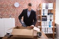 Businessman Packing His Belongings In Cardboard Box