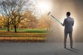 The businessman painting nature picture with roller brush