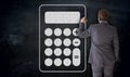 Businessman paints calculator icon on blackboard concept