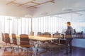 Businessman in panoramic meeting room corner, wood